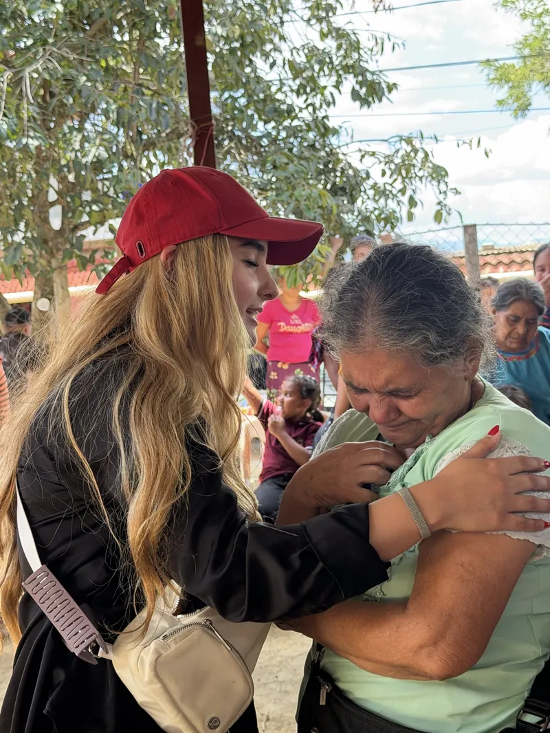 Una voluntaria abraza a una señora de la comunidad
