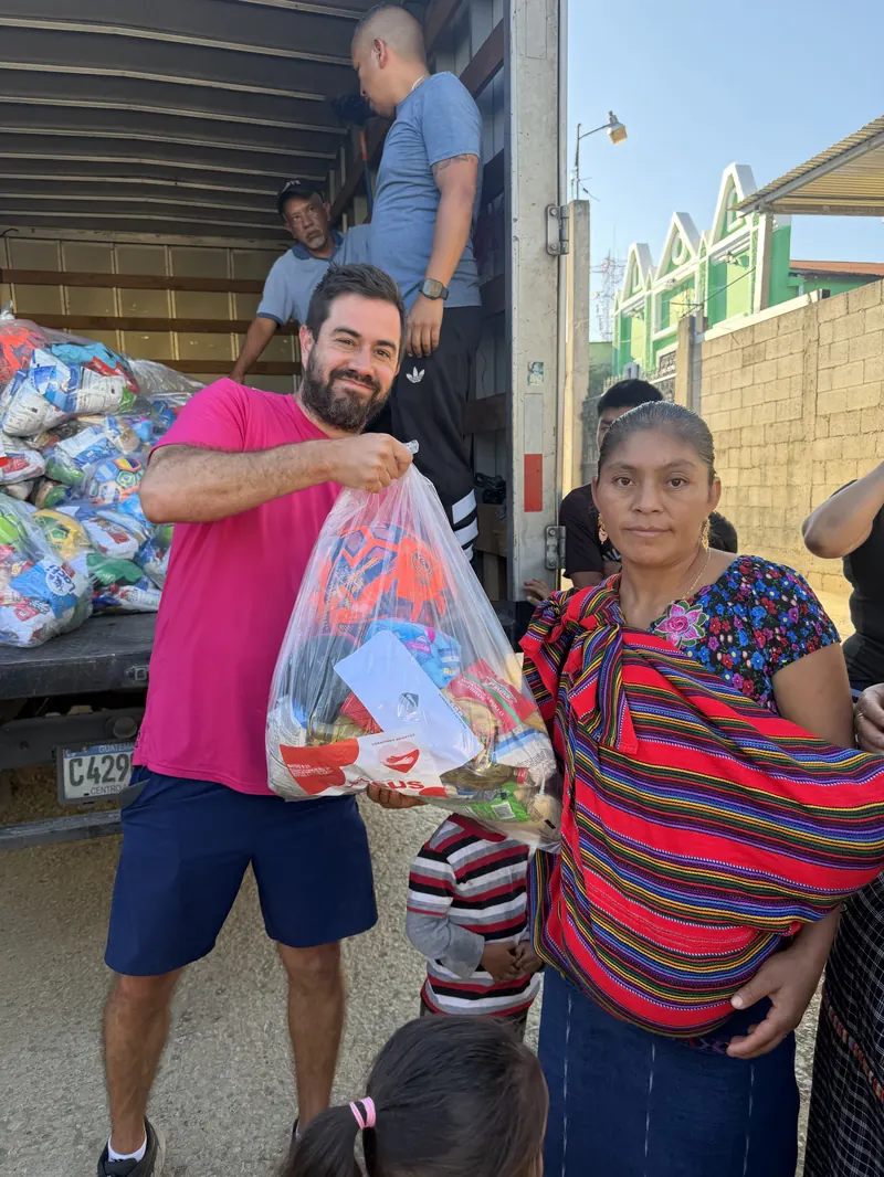 Voluntario entrega una bolsa a una señora