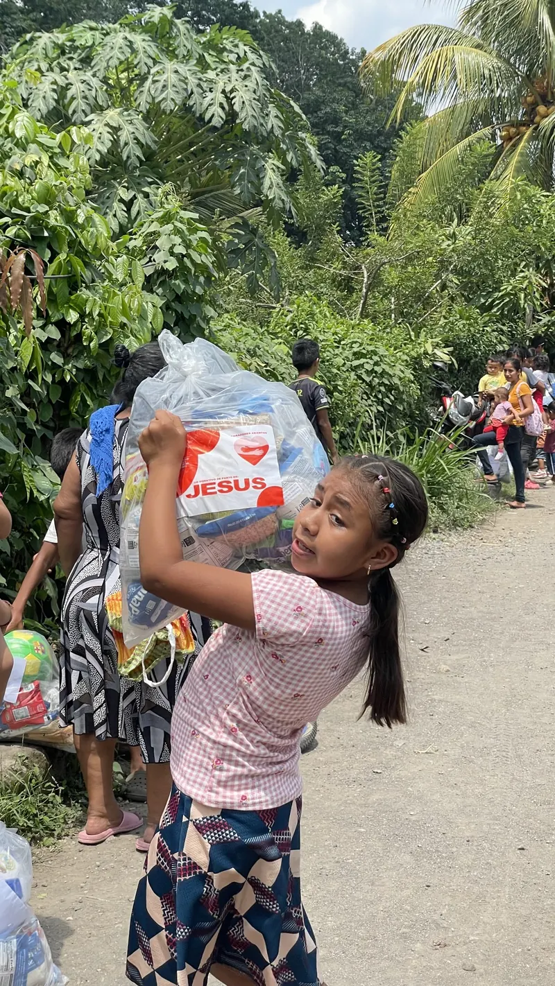 Niña levanta su bolsa con alegría